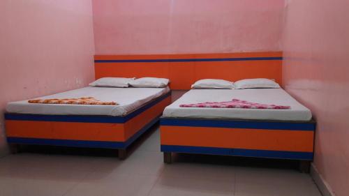 加雅Hotel Utsav & Marriage Hall的两张睡床彼此相邻,位于一个房间里
