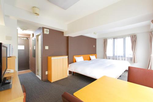 东京FLEXSTAY 白金旅馆的一间酒店客房,配有一张床和一台电视