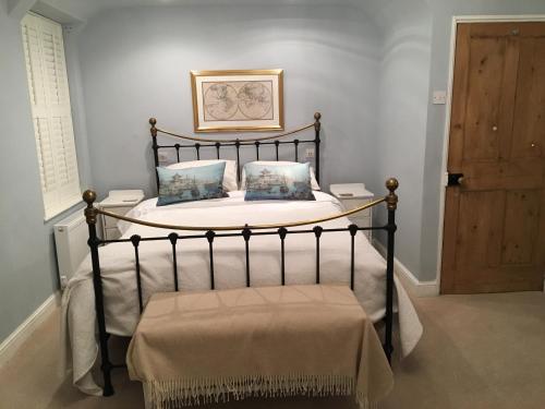 布罗德韦SmallBrook Cottage的一间卧室配有一张带锻铁框架的床