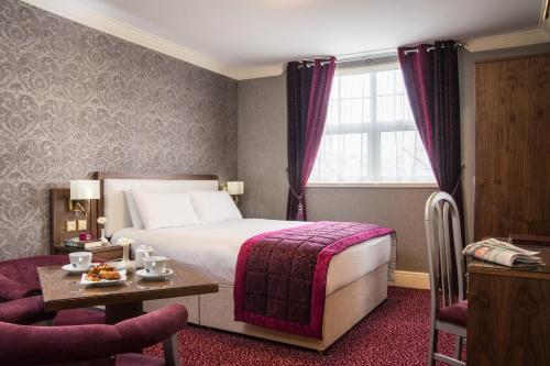 班多伦大北方酒店的酒店客房设有一张大床和一张桌子。