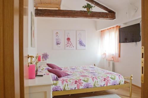 威尼斯Appartamento Calle dei Preti info at yourhomefromhomeinvenice-venicerentalapartments dot it的一间卧室配有一张带粉色和紫色枕头的床