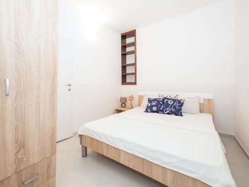 蒂瓦特Apartments Elena的一间卧室配有带白色床单和蓝色枕头的床。