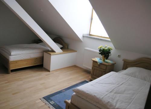 Pliening伏耳切汉墨兰德加斯托酒店的阁楼卧室设有两张床和窗户。