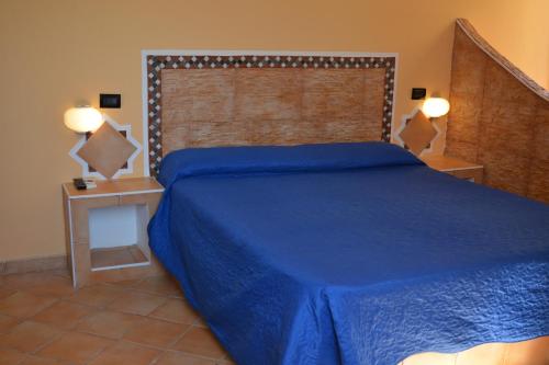 兰佩杜萨Hotel Mare Blu的一间卧室配有一张蓝色的床和一个大床头板