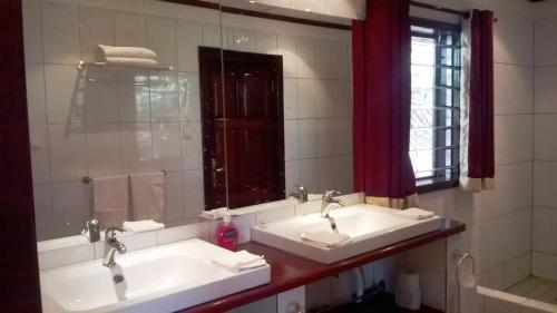 Tanji怀特宏丝酒店的浴室设有2个水槽和镜子
