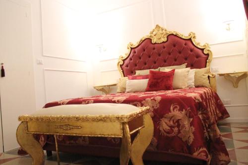 比谢列DONNA LUCREZIA b&b Boutique Hotel Style的一间卧室配有一张带红色床头板和凳子的床