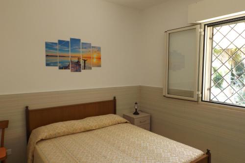 托雷拉皮罗Villa Aloe的一间卧室设有一张床和一个窗口