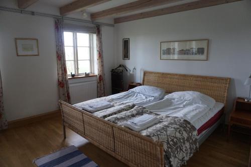 奇维克Adagio på Österlen的一间卧室配有一张带白色床单的床和一扇窗户。