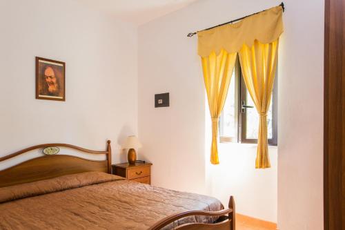 维耶斯泰Tenuta Padre Pio的一间卧室设有床和黄色窗帘的窗户