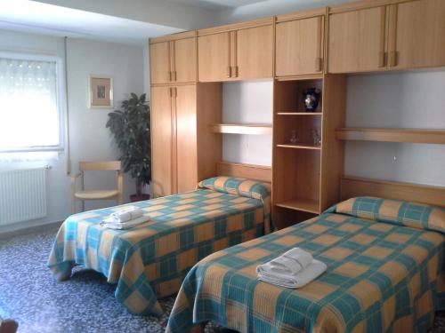 萨拉戈萨拉卡斯塔膳食酒店的客房设有两张床和带毛巾的橱柜。
