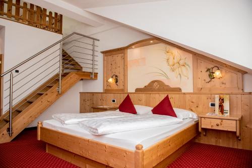 圣坎迪朵Loewe Dolomites的一间卧室设有一张大床,并有楼梯