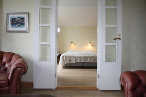 KökarBrudhäll Hotel & Restaurant的一间设有床铺的卧室,位于一个设有两个开放式门的房间