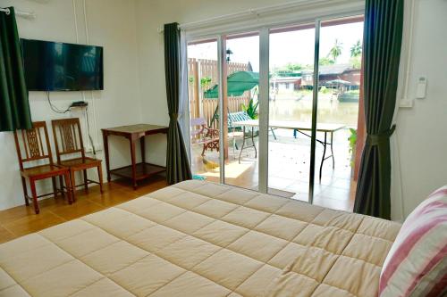 安帕瓦班桑湾民宿 的一间卧室设有一张大床和一个滑动玻璃门