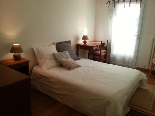 马恩河畔布里阿维斯花园皮埃尔·居里住宿加早餐旅馆的一间卧室配有一张带白色床单的床和一扇窗户。