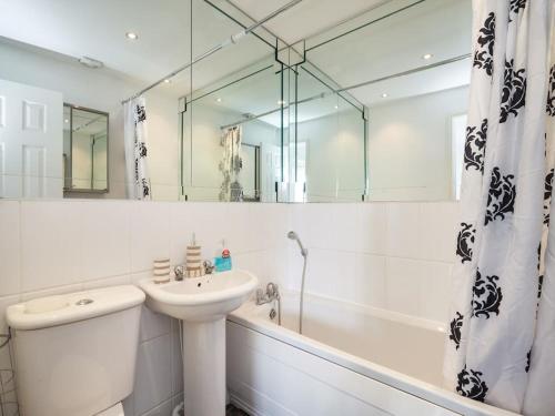 曼彻斯特My-Places Abbotsfield Court Townhouse的白色的浴室设有水槽、浴缸和镜子