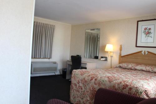 韦斯特菲尔德榆树汽车旅馆的酒店客房配有一张床、一张书桌和一个浴缸。