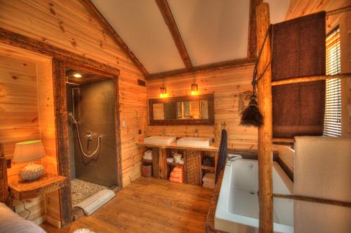 拉马巴耶Le St Bernard - Les Chalets Spa Canada的小木屋内的浴室设有浴缸和水槽