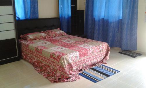 日得拉日得拉克科基帕亚迪民宿的一间卧室配有蓝色窗帘的床
