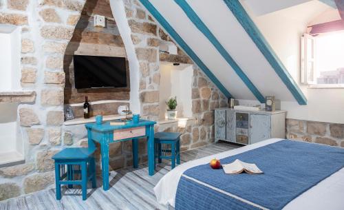 杜布罗夫尼克鲁斯蒂科旅馆 的一间卧室配有一张床、一张桌子和一台电视。