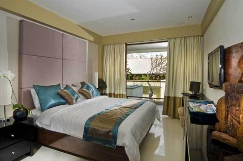 库塔库塔豪华酒店的一间卧室设有一张大床和一个窗户。