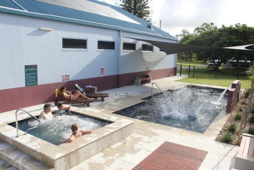 赫维湾弗雷泽旅行家公园酒店的两个孩子在后院的游泳池玩耍