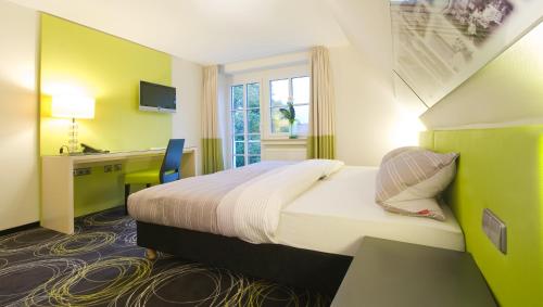 特罗辛根Hotel Landgasthof Bären的酒店客房设有一张大床和一张书桌。