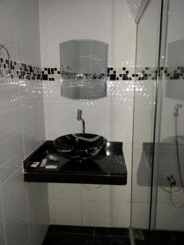 São JorgeShopping Motel Santa Maria do Pará的一间带水槽和玻璃淋浴的浴室