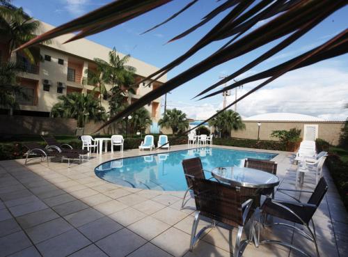阿尔塔米拉Augustu's Hotel的一个带桌椅的游泳池和一个庭院
