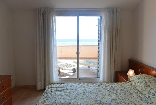 帕尔斯Apart Port Pals Duplex的一间卧室配有一张床,享有海滩美景