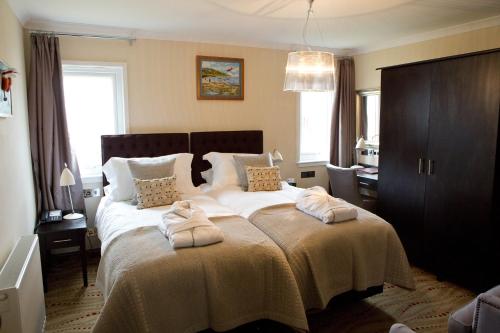 斯坦利海滨精品酒店的一间卧室配有一张大床和两条毛巾