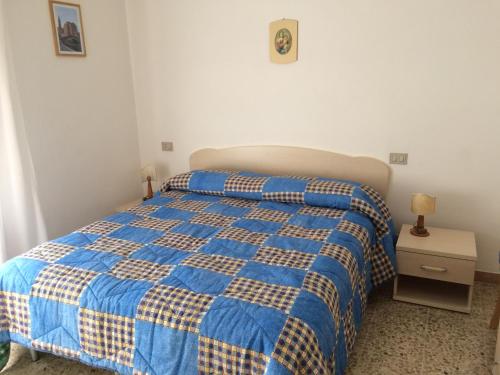 索托马里纳诺瓦德尔酒店的一间卧室配有蓝色和黄色的床以及床头柜。