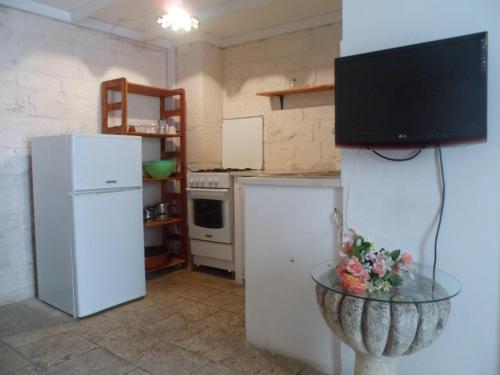 奥斯图尼Ivory的厨房配有冰箱和电视桌。