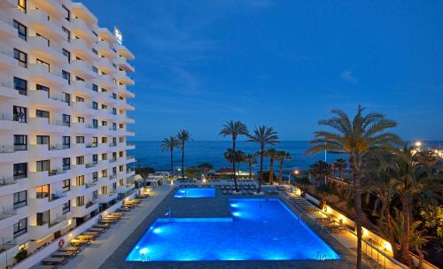 多列毛利诺斯Hotel Ocean House Costa del Sol, Affiliated by Meliá的享有酒店的景色,在晚上设有游泳池