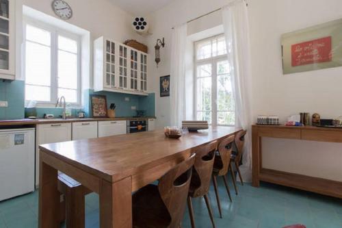 耶路撒冷塔比耶珍宝全新公寓的厨房配有大型木桌和椅子
