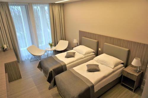 波莫瑞地区卡缅Mieszko II的酒店客房设有两张床和一张桌子。