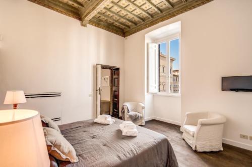 罗马Piazza Farnese exclusive view 2 bedroom en suite的一间卧室配有一张床、两把椅子和一个窗户