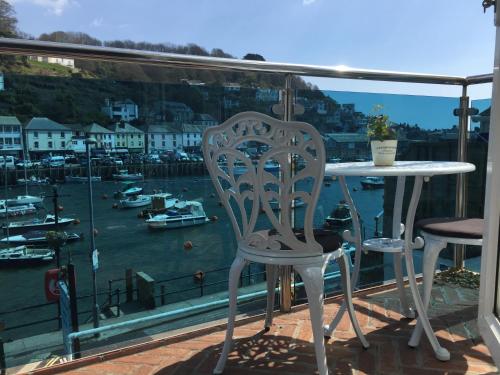 西卢港拾贝者旅馆的俯瞰码头的阳台配有桌椅
