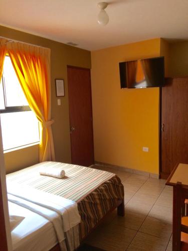 特鲁希略Hostal El Pillkay的一间卧室设有一张床和一个窗口