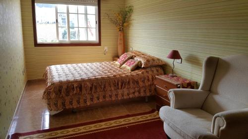 米尼奥Mino Apartamento的卧室配有床、椅子和窗户。