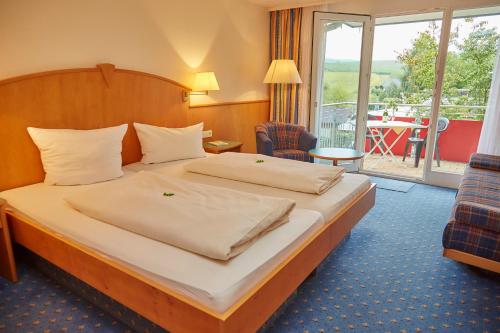 勒文斯泰因罗杰弗莱尔兰德加索夫酒店的酒店客房设有一张床和一个阳台。