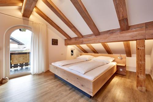 加尔米施-帕滕基兴Ferienwohnung Wittmann的一间卧室设有一张带木梁的大床