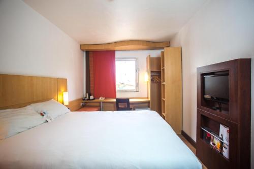 伊凯贾宜必思拉各斯机场酒店的卧室配有白色的床和电视。