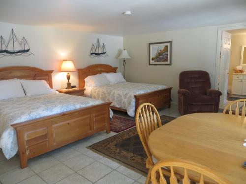 吉布森斯Caprice的酒店客房设有两张床和一张桌子。