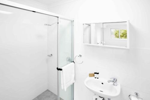 纽卡斯尔纽卡斯尔渴望酒店的白色的浴室设有水槽和淋浴。