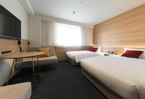 东京新宿西铁酒店的酒店客房设有两张床和一张桌子。