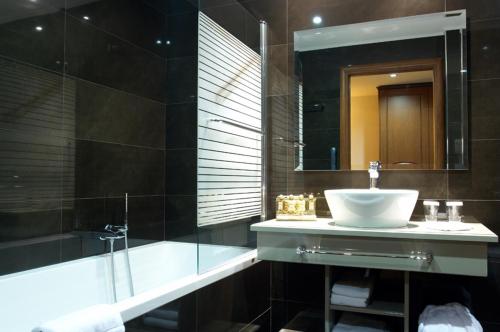 阿拉霍瓦Tagli Resort & Villas的一间带水槽、淋浴和镜子的浴室