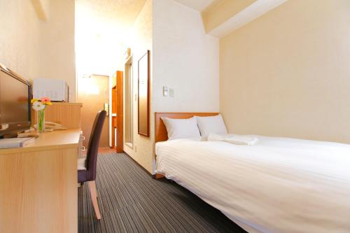 东京FLEXSTAY 常盤台旅馆的酒店客房设有一张大床和一张书桌。