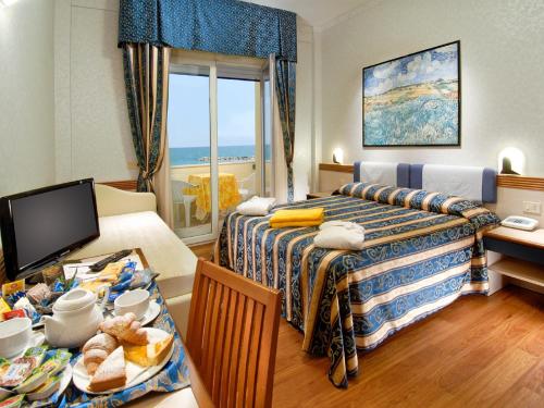 丽都迪萨维奥科罗拉多斯特朗酒店的酒店客房,设有两张床和一张带食物的桌子