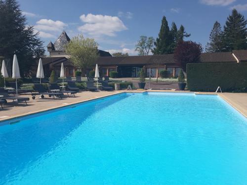 索恩河畔贝尔维尔皮扎伊城堡酒店的一座大蓝色游泳池,位于房子前