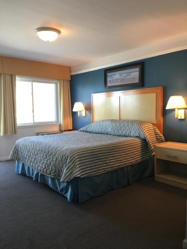 蒙托克大西洋海滩皇家度假酒店的一间卧室配有一张带蓝色墙壁的大床